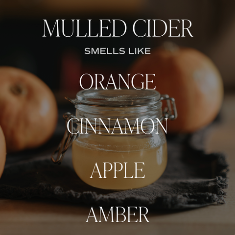 Glass jar of mulled cider with pumpkins in the background, text describing scents.