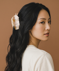 Woman with a shell hair accessory against a brown background