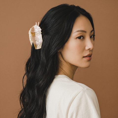 Woman with a shell hair accessory against a brown background